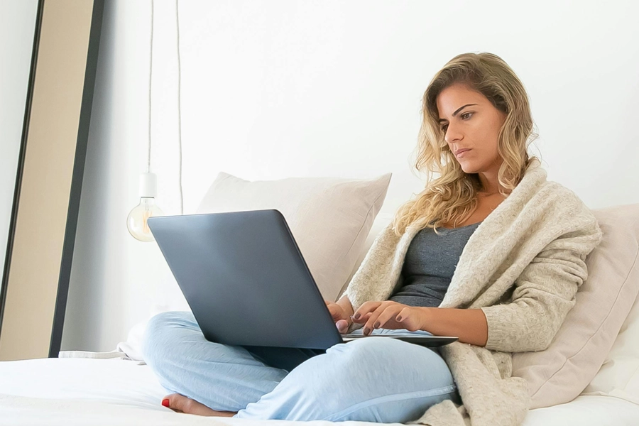 woman sitting on sofa with laptop open in lap